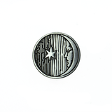 A silver metal moon-with-a-face pin, with antique artwork from the Flammarion Engraving.