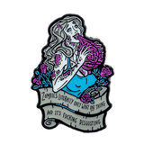 An enamel pin of a zombie woman with pale grey skin and grey hair. Her wounds are pink and she's eating a pink brain, with pink hearts and roses surrounding her. A grey banner below her says "Zombies literally only want one thing and it's fucking disgusting".
