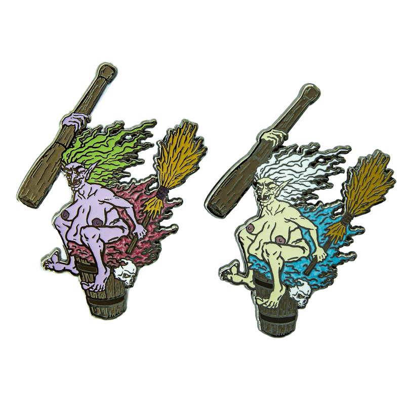 Two enamel pins of Baba Yaga the crone witch, riding her mortar and pestle with broom in hand. She has taken off her clothing and sits on it with a wicked smile. One pin has purple skin and green hair, and her discarded clothing is red. The other has greenish-white skin and white hair, and her stripped clothing is blue.