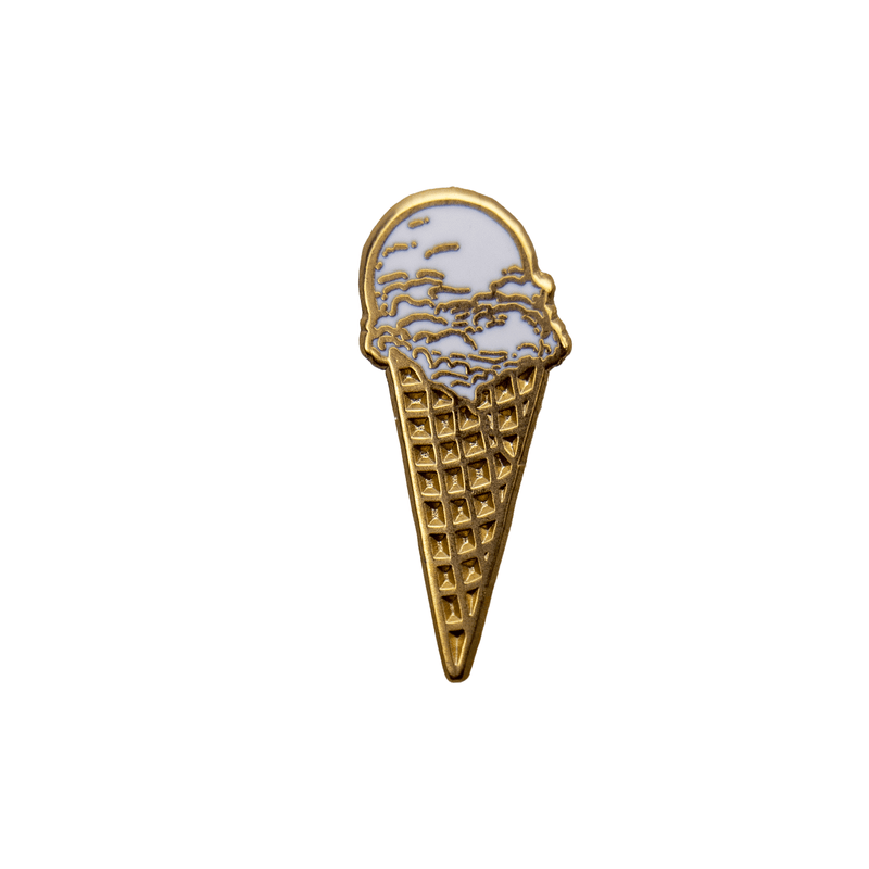 A gold metal and white enamel pin of a vanilla ice cream waffle cone.