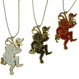 Three Krampus gold plated enamel ornaments in black, white, and red.