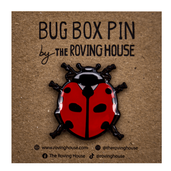 A red, black, and white enamel pin of a nine spotted ladybug.