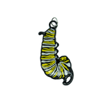 A black, white, and yellow enamel charm of a monarch butterfly caterpillar in the J shape.