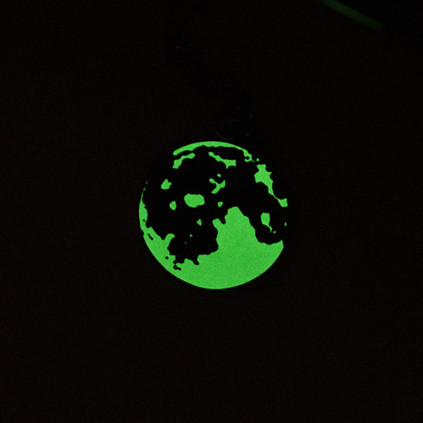 The enamel moon pendant glowing green in the dark.