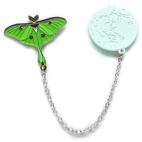 An enamel pin set of a green luna moth and the moon, connected by a silver chain.