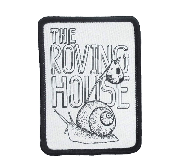 A black and white woven patch of a snail carrying a bindle. Behind him is the text "The Roving House".